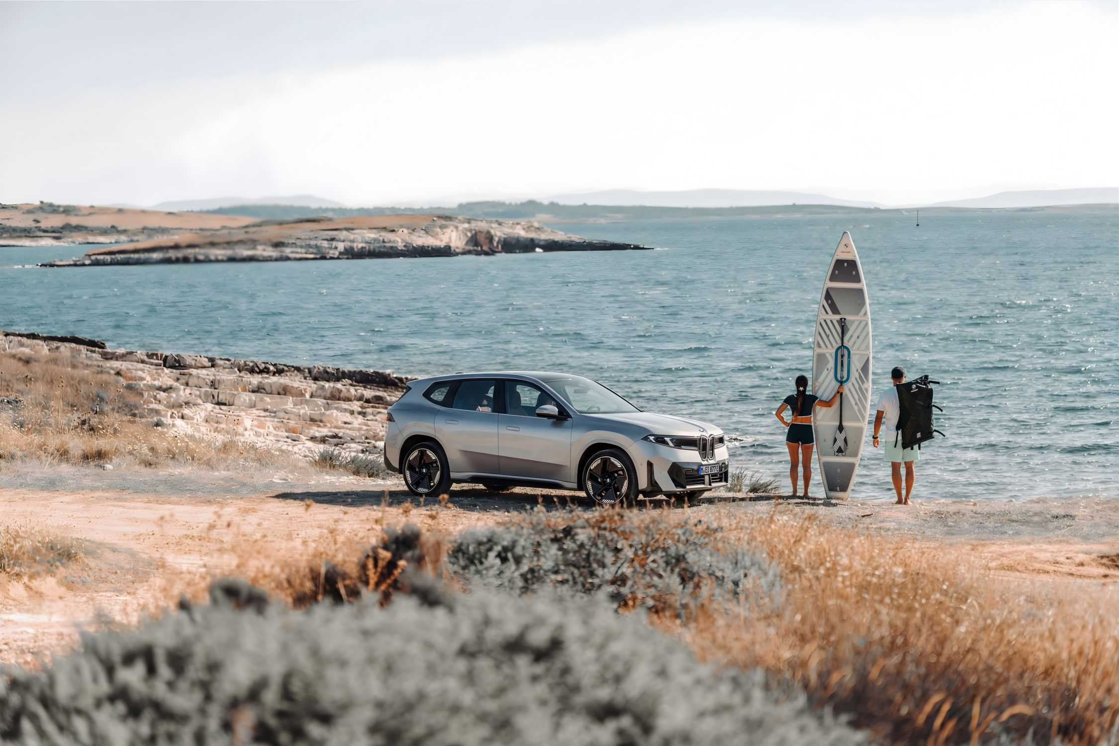 BMW iX3 electric vehicle travelling on a summer road