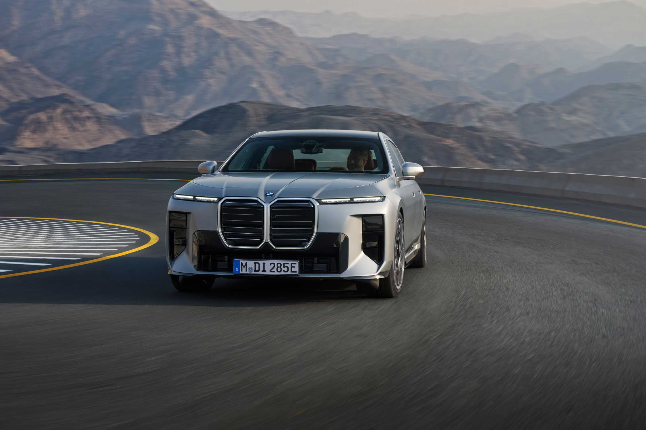 BMW i7 electric sedan driving on a mountain road