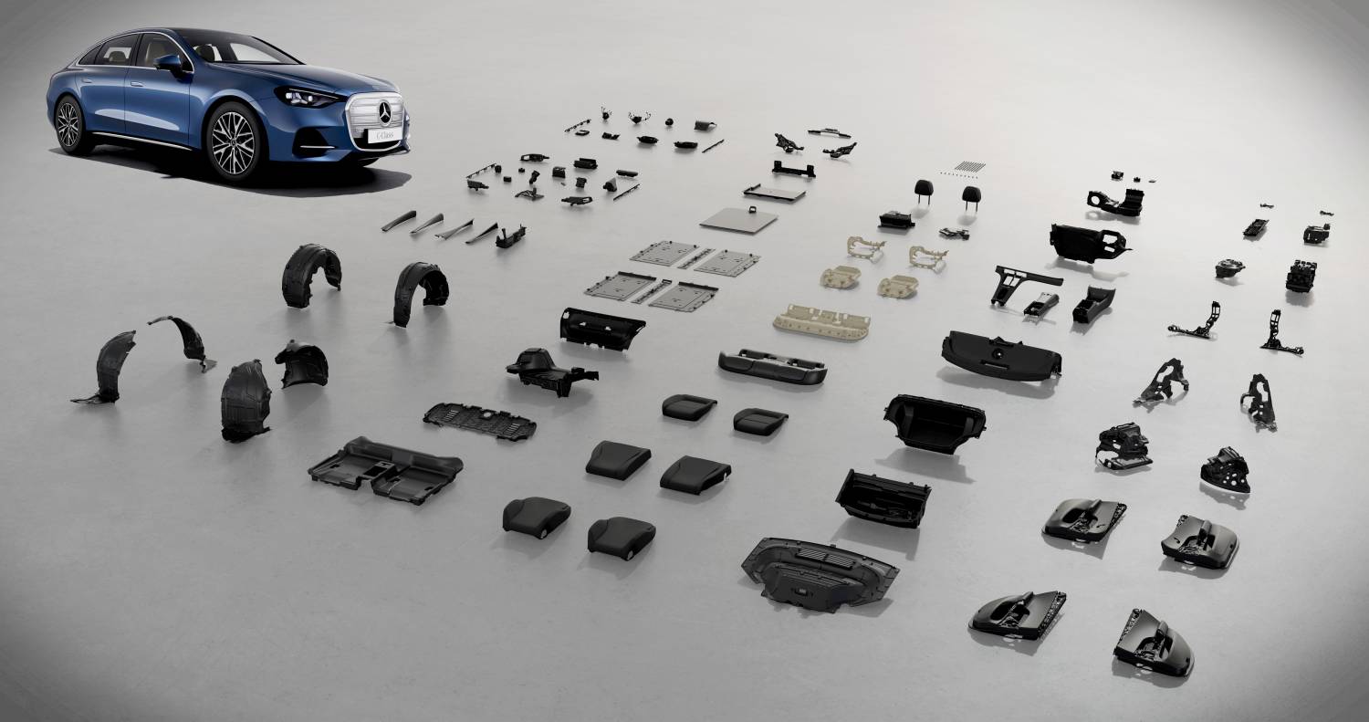 Blue Mercedes-Benz electric C-Class displayed beside components laid out for its environmental assessment